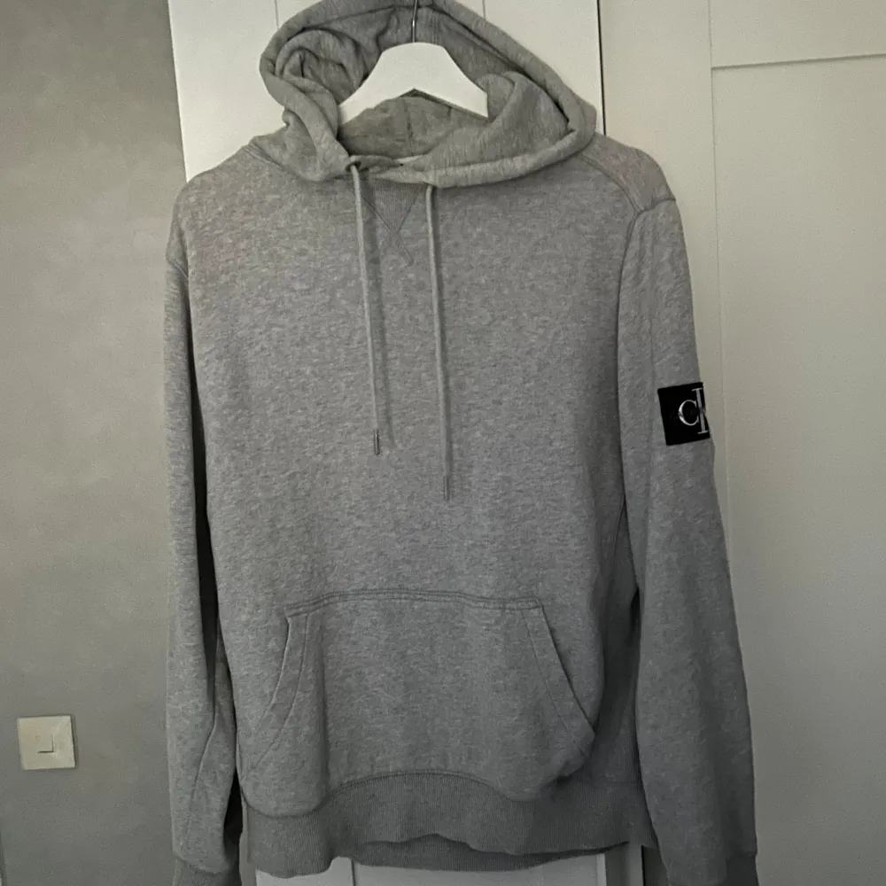 Säljer en snygg och bekväm grå hoodie från Calvin Klein Jeans. Har blivit sparsamt använd och är i gott skick. Storlek M men passar även S. Tröjor & Koftor.