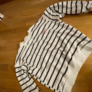 Randig tröja från H&M - Säljer en superfin randig tröja från H&M i storlek XS. Den är vit med svarta ränder och har långa ärmar. Perfekt för en casual look! Tröjan är i bra skick men har lite blåa fläckar och en brun/beige från Liseberg men syns inte när man har på sig den