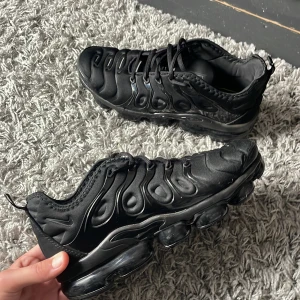 Svarta Nike Air Vapormax Plus - Ett par svarta Nike vapormax plus skor i storlek 45. Dom är använda några gånger men har inga skador. Tvättas innnan frakt.