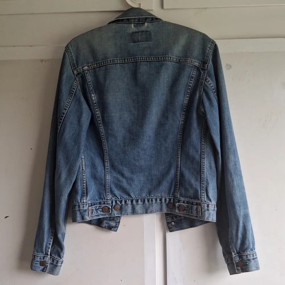 Säljer en snygg och klassisk jeansjacka från Levi's i storlek M. Jackan är i blå denim med knappar framtill och två bröstfickor med knappstängning. Perfekt för vår och höst! 🧥. Jackor.