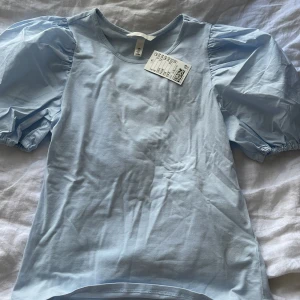 Ljusblå topp med puffärmar från H&M - T-shirt från hm😇 aldrig använd!