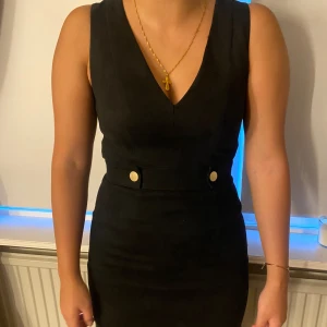 Klänning - En svart klänning med eleganta knappar som gör den extra unik