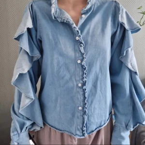 Jeansskjorta med volanger - BIKBOK - Jeansskjorta med volanger från Bikbok, nyskick. Storlek XS. Väldigt skönt material.