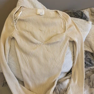 Beige ribbad tröja - Säljer en superfin beige ribbad tröja i storlek S. Den har en snygg v-ringad design och långa ärmar, perfekt för både vardag och fest. Tröjan är i bra skick och passar perfekt till höst- och våroutfits.