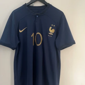 Frankrike 2022 - Frankrikes matchtröja från vm i Qatar 2022 med Kylian Mbappé på ryggen. Bvsa