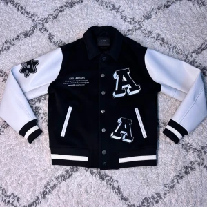 Axel Arigato Varsity Jacket - Snygg svart och vit Varsity jacka från Axel Arigato. Köpt i Arigatos butik i Stockholm för något år sedan. Aldrig använd och endast hängt i garderoben. Arigato dustbag med köptagg tillgår med köpet. Storlek S passar M