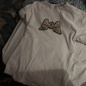 Vit t-shirt från Moncler och Palm angels - Snygg vit t-shirt från Moncler och Palm angels  med ett coolt broderat motiv av vingar och texten 'Angels' på baksidan. Perfekt för en stilren och avslappnad look. Öppen för byten och skriv pris förslag kan du skriva i våran chat köpt är köpt 
