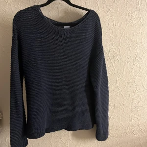 Mörkblå stickad tröja från Zara - Säljer en snygg mörkblå stickad tröja från Zara. Perfekt för kyliga dagar med sin mysiga och luftiga design. Tröjan har långa ärmar och en rund halsringning.