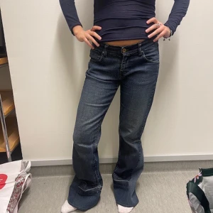 Mörkblå bootcut jeans - Snygga mörkblå bootcut jeans med låg midja och klassisk femficksdesign. Perfekta för en avslappnad stil med en touch av retro. Passar bra till sneakers eller klackar. Köota secondhand, omsydda av mined uf