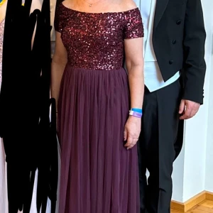 Vinröd balklänning - Otrolig, vinröd balklänning med nedhasade axlar, paljetter och tyllkjol från Maya Deluxe. Endast använd vid ett tillfälle så den är i toppskick! Kortad för att passa någon på ca 160 cm. Man känner sig verkligen såå fin i den här! 🥹❣️