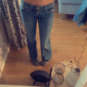 Blå bootcut jeans - Snygga blå bootcut jeans med låg midja och klassisk femficksdesign. Perfekta för en avslappnad stil.