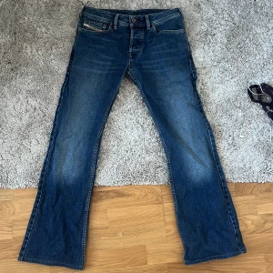 Lågmidjade bootcut jeans från Diesel - Ett par svinsnygga blå lågmidjade bootcut jeans! Säljer då de tyvärr var för korta för mig som är ca 170! Strl 29 i midjan men passar mindre också! Tveka inte på att skriva frågor! 
