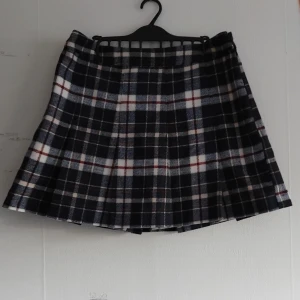 Rutig kjol från H&M - En rutig kjol i marinblå, röd och vit från H&M. Har shorts under. Above knee, veckad och högmidjad. Aldrig använd 