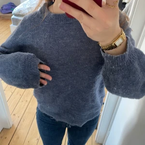 Mörkblå stickad tröja - Säljer en mysig mörkblå stickad tröja med långa ärmar och ribbade muddar. Perfekt för kyliga dagar. Tröjan har en klassisk rund halsringning och en avslappnad passform.❣️❣️