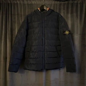 Mörkblå pufferjacka  Stone Island - Säljer en mörkblå pufferjacka från Stone Island med ogga på ärmen. Jackan är i vackert skick och säljer eftersom den inte kommer till användning längre.  Kontakta gärna vid frågor ☺️(c.o.p.y)