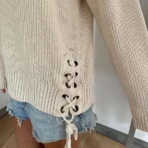 Mörkblå stickad tröja med snörning - !!Första bilden är lånad!! Säljer en likadan fast i mörkblå!! Kanske aningen mindre i storlek än på första men annars är dem identiska🥰