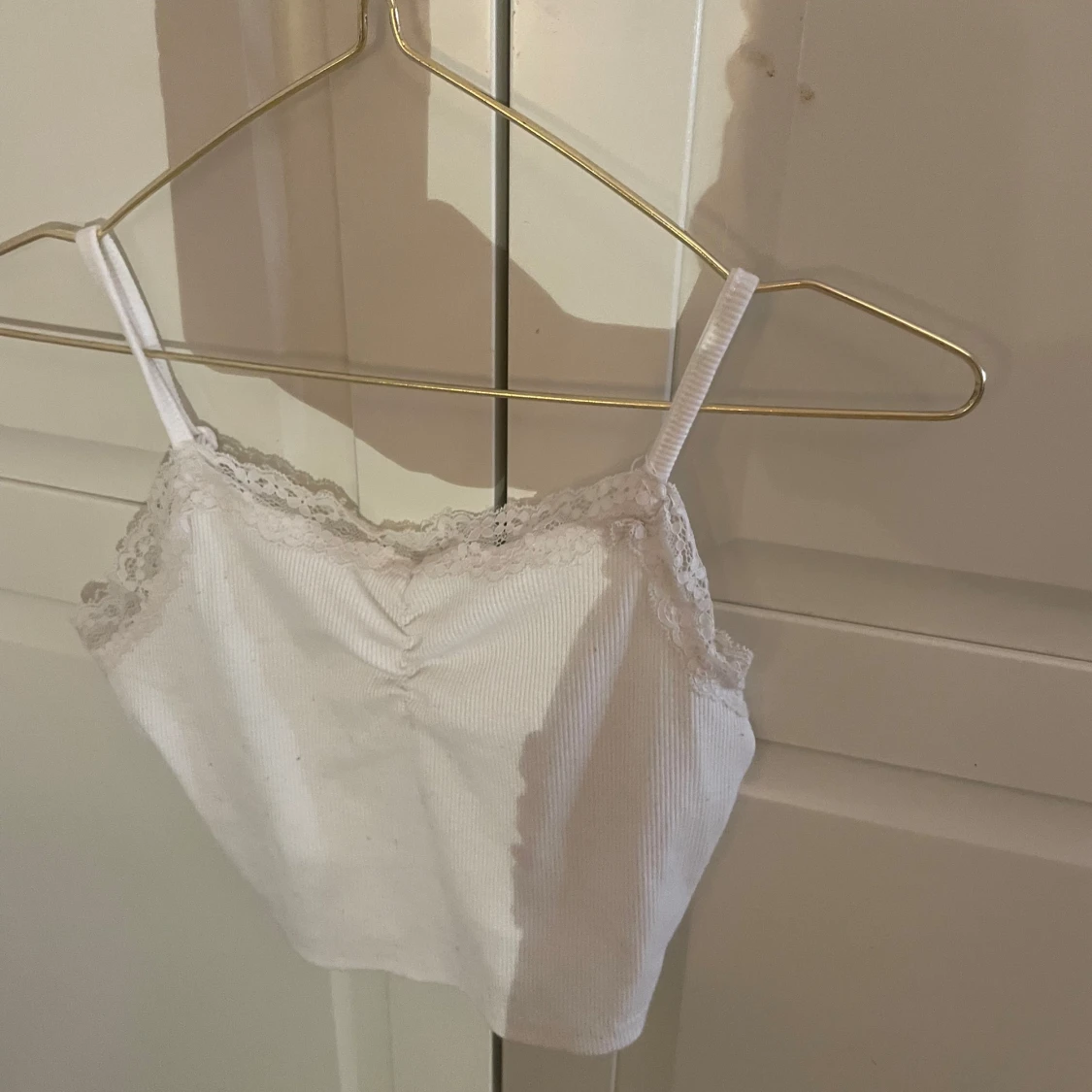 Vit ribbad linnetopp med spetsdetaljer