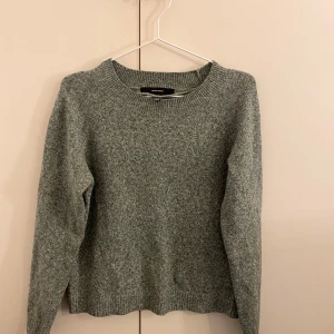 Grå stickad tröja från H&M - Mysig grön stickad tröja med rund halsringning och långa ärmar. Perfekt för kyliga dagar och enkel att matcha med jeans eller kjol. Ett måste i garderoben för en stilren look.