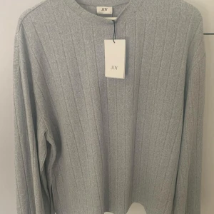 Grå ribbad tröja från JDY & kjol  - Snygg grå ribbad tröja från JDY med långa ärmar. Perfekt för en stilren och bekväm look. Passar bra till både vardag och mer uppklädda tillfällen. Tröja - L Kjol - XL 