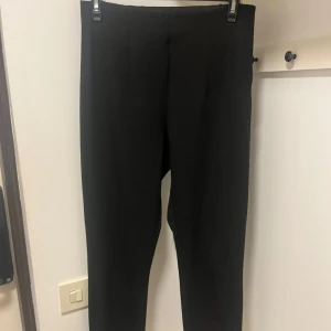 Figurnära kostymbyxa från Gina Tricot - Mycket bra skick! Byxorna är jätte sköna men lite små i storlek. Skulle säga att de passar storlek 38. Har en liten slits på slutet av benen. Sömen på insidan av ena foten har gått upp så tyget kan vridas ut lite. Inget som är trasigt och går att sy.