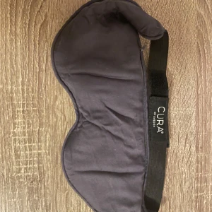 Sovmask från Cura of Sweden - Sovmask med tyngd som ska bidra till ökad avslappning. Från märket Cura of Sweden.   Yttertyg i bambu och fyllning av bomull och glaspärlor. Kan maskintvättas i 40 grader. Använd 1 gång. Originallåda saknas.   Nypris ca 400 kr