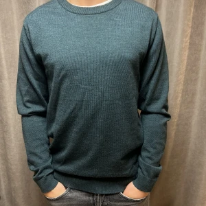 A Day's March 100% Merino - Säljer en stilren grön tröja från A Day's March i 100% fin merinoull | modellen på bilden är 170 cm | Fint skick |