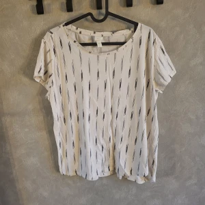 Mönstrad topp från H&M - Säljer en vit topp från H&M med svart mönster, storlek L