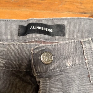 Grå shorts från J. Lindesberg i jeans - Säljer ett par grå shorts från J. Lindeberg. De har en klassisk design med fem fickor och upprullade benslut. Jeans 