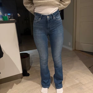 Blå bootcut jeans - Snygga blå bootcut jeans med hög midja. Perfekta för en avslappnad stil med en klassisk touch. De har en knapp och dragkedja framtill samt fickor både fram och bak. Stolek S. Ifrån only. 