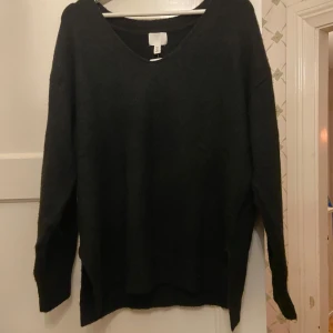 Svart tröja från H&M - Säljer en stilren svart tröja från H&M med v-ringning. Tröjan har långa ärmar och en klassisk design som passar perfekt till vardags. Perfekt för höst och vinter! Aldrig använd med prislappen kvar