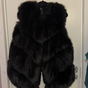 Svart pälsväst - Snygg och lyxig svart pälsväst som ger en elegant touch till din outfit. Perfekt för fest. Köptes för 800kr