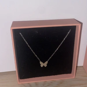 Silverhalsband med fjäril från Edblad - Elegant silverhalsband från Edblad med en fin fjärilsberlock. Storlek 10x9 mm, kedjans justerbara längd 42-45 cm. Blankt rostfritt stål, nickelsäkert. Köpte den för 299kr men säljer för 215