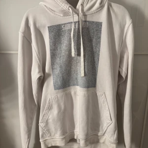 Vit hoodie med tryck - Säljer en vit hoodie med ett större blå/grått tryck på framsidan från the cool elephant. Den kommer inte till användning och har ngn fläck längst ut på ärmen. 
