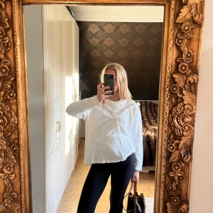 Vit blus med spetsdetaljer - Säljer en stilren vit blus med vackra spetsdetaljer vid halsen. Blusen har långa ärmar och en lös passform, perfekt för en chic och avslappnad look🌟❤️
