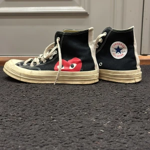 Converse x Comme des Garçons Play sneakers - Svarta Converse All Star sneakers i samarbete med Comme des Garçons Play. Skorna har det ikoniska röda hjärtmotivet på sidan och klassisk snörning. Perfekta för en stilren och trendig look. Storlek 40 men passar 41 bra också