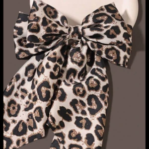 Leopardmönstrad hårspänne - Snygg leopardmönstrad hårspänne med stora rosett. Perfekt för att ge din outfit en djärv touch. Tillverkad i ett mjukt och följsamt material.
