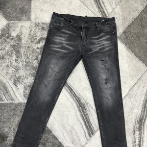Svarta jeans från Dsquared2 - Snygga svarta jeans från Dsquared2 med en cool slitningseffekt. De har en klassisk femficksdesign och en knappgylf. Perfekta för en trendig look. ( priset kan diskuteras )