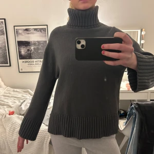 Grå stickad med turtleneck  - Säljer en mysig grå stickad polotröja med ribbade detaljer vid krage, ärmslut och nederkant. Finns slits. Slutsåld och väldigt populär! Storlek XS men passar mig som brukar ha S o M
