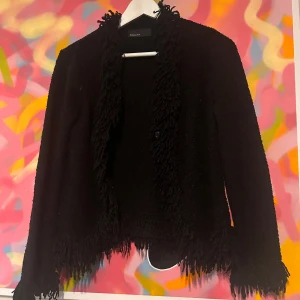 Stickad kofta med fransar  - Snygg svart stickad kofta med fransdetaljer från KappAhl.