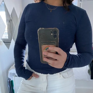 Mörkblå ribbad tröja från Dazy - Säljer en stilren mörkblå ribbad tröja från Dazy. Tröjan har långa ärmar och en rund halsringning, perfekt för en avslappnad look. Passar bra till både jeans och kjol.