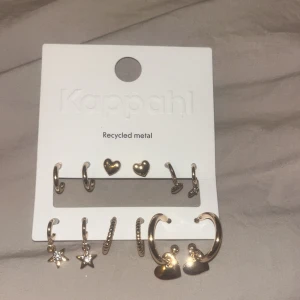 Örhängeset i återvunnet metall från Kappahl - Snyggt örhängeset från Kappahl i återvunnet metall. Setet innehåller flera olika stilar, inklusive hjärtan och stjärnor. Perfekt för att mixa och matcha efter humör och tillfälle.