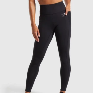 Svarta leggings från Gymshark (LAPPEN KVAR) - Snygga och bekväma svarta leggings från Gymshark. Perfekta för träning med hög midja och en tight passform som ger stöd och komfort. Diskret logga på låret. Aldrig använda!