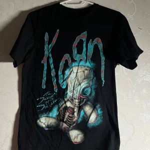 Svart Korn T-shirt - Cool flerfärgad Korn t-shirt. Tryck på både bak och framsida med loggan i blått och rött. Säljer då den är lite för liten och aldrig kommer till användning. Perfekt för fans av bandet!