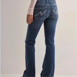 Blå bootcut jeans Nelly - Snygga blå bootcut jeans med låg midja och coola sömmar på bakfickorna. Knappt använda! 