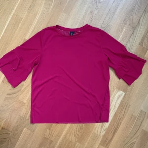 Röd topp från Zoul - Säljer en snygg röd topp från Zoul med trekvartsärmar och en bekväm passform. Perfekt för att liva upp garderoben med en färgklick. Toppen har en enkel design som gör den lätt att matcha med olika outfits.