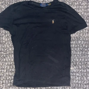 Svart t-shirt från Polo Ralph Lauren - Säljer en svart t-shirt från Polo Ralph Lauren i custom slim fit. Den har en liten broderad logga på bröstet. Perfekt för en stilren look. Priset kan diskuteras✅