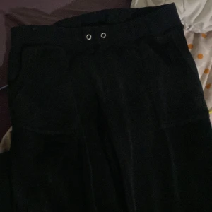 Svarta mjukisbyxor med snörning - Säljer ett par svarta mjukisbyxor med snörning i midjan och fickor med knappar bak. Perfekta för en avslappnad stil. Det är en Juicy köpt för fem månader sen använt som knappast köpte den för 2300kr under delen för 1100kr och över delen för 1200kr och säljer den nu för 1000kr eftersom jag inte har på mig den är ingen mjukis tjej överdelen är i storlek L passsae även som M och under delen är i M 