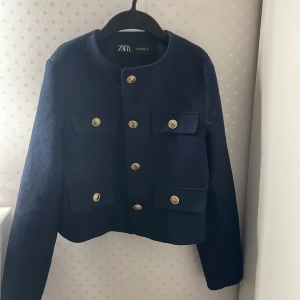 Zara jacka  - Säljer denna mörkblåa zara jackan med guldiga knappar. Storlek S, skick 9/10, använd ett få tal gånger. Ny pris 600 kr, hör av er vid frågor eller funderingar.
