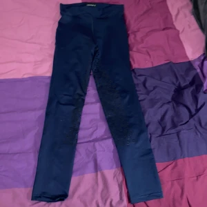 Mörkblåa ridbyxor från Equipage - Snygga mörkblå ridbyxor från Equipage, perfekta för ridning. Tillverkade i 88% micro poly och 12% spandex för en bekväm och stretchig passform. De har en hög midja och en tight passform som ger bra stöd.