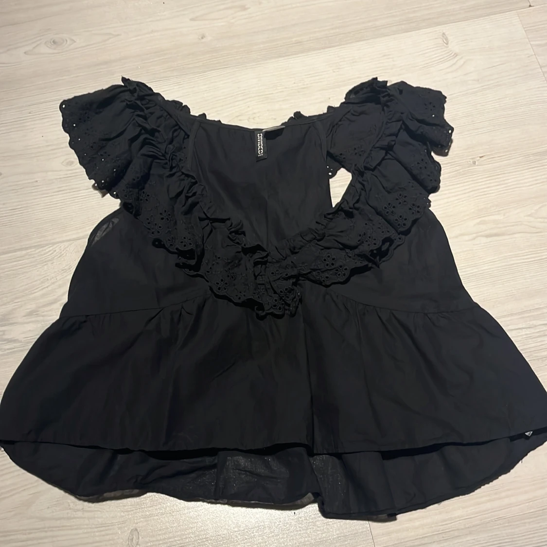 Svart blus med volangdetaljer